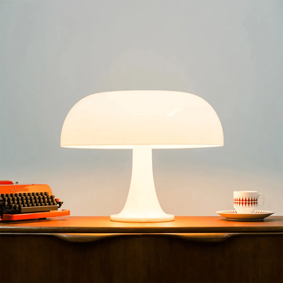 Table lamp on a wooden surface with a typewriter and cup in the background